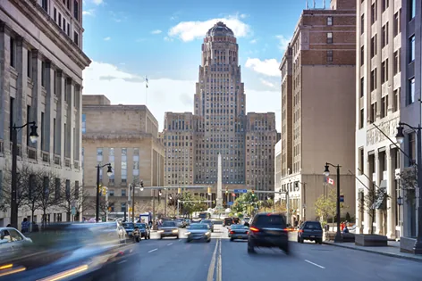 Buffalo City Hall's Art Deco tower at the end of Court Street under a bright blue sky