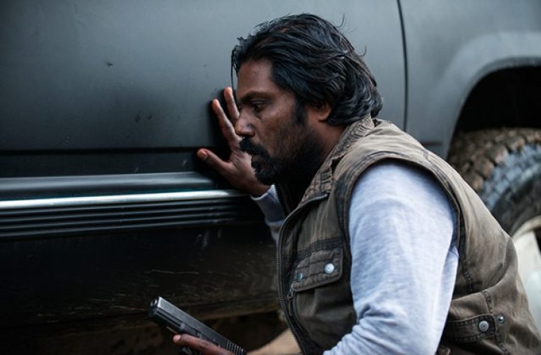 Jesuthasan Antonythasan (Dheepan) behind the car in Jaques Audiard’s DHEEPAN. Courtesy of Paul Arnaud. A Sundance Selects release.
