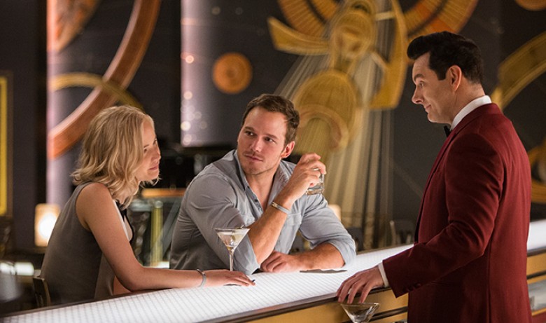 Aurora (JENNIFER LAWRENCE) and Jim (CHRIS PRATT) pay Arthur (MICHAEL SHEEN) a visit at the Grand Concourse Bar in Columbia Pictures’ PASSENGERS. PHOTO BY: Jaimie Trueblood ©2016 CTMG, Inc. All Right Reserved.